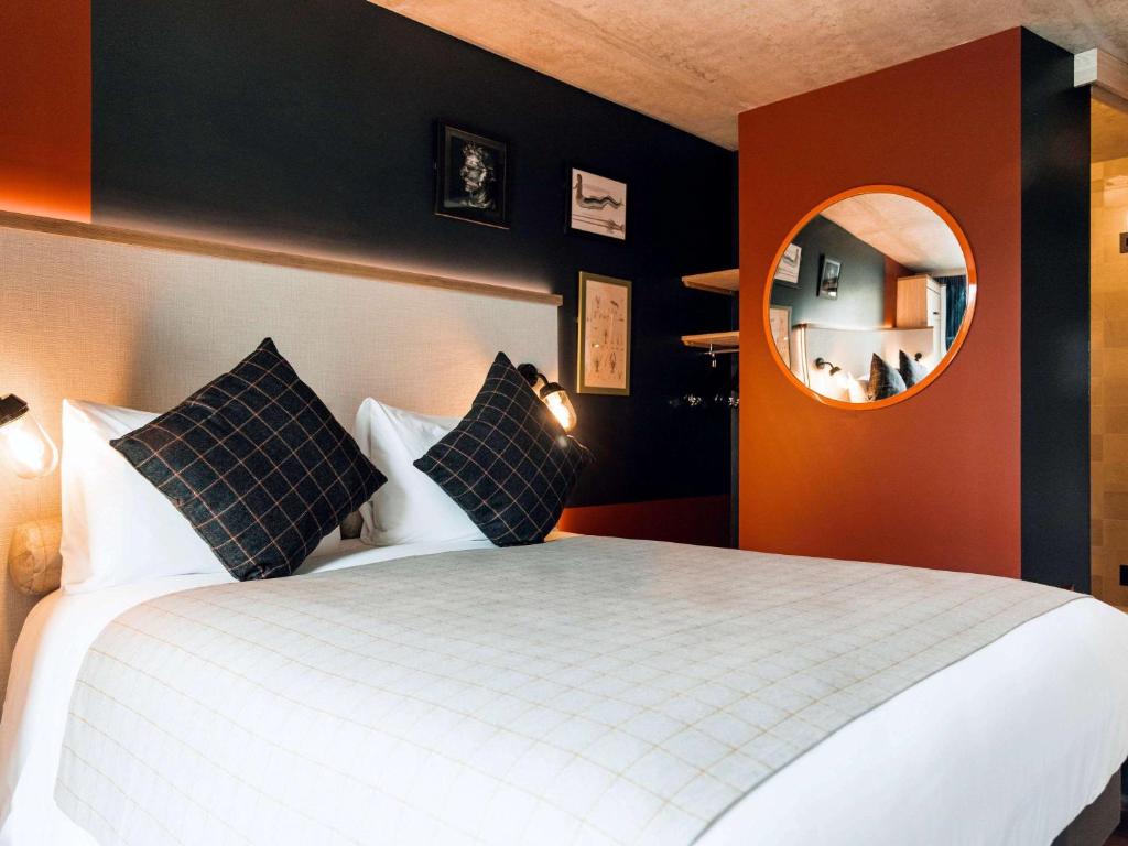 a bedroom with a large bed and a mirror at greet Hotel La Rochelle Centre in La Rochelle