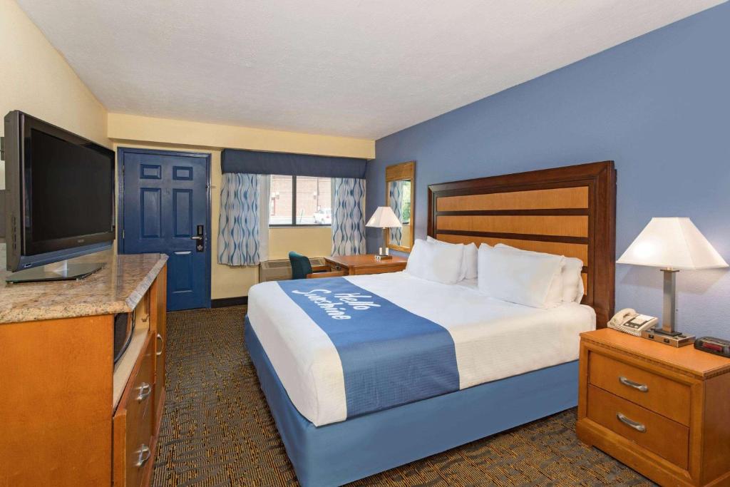 a hotel room with a bed and a flat screen tv at Days Inn by Wyndham Renfro Valley Mount Vernon in Mount Vernon