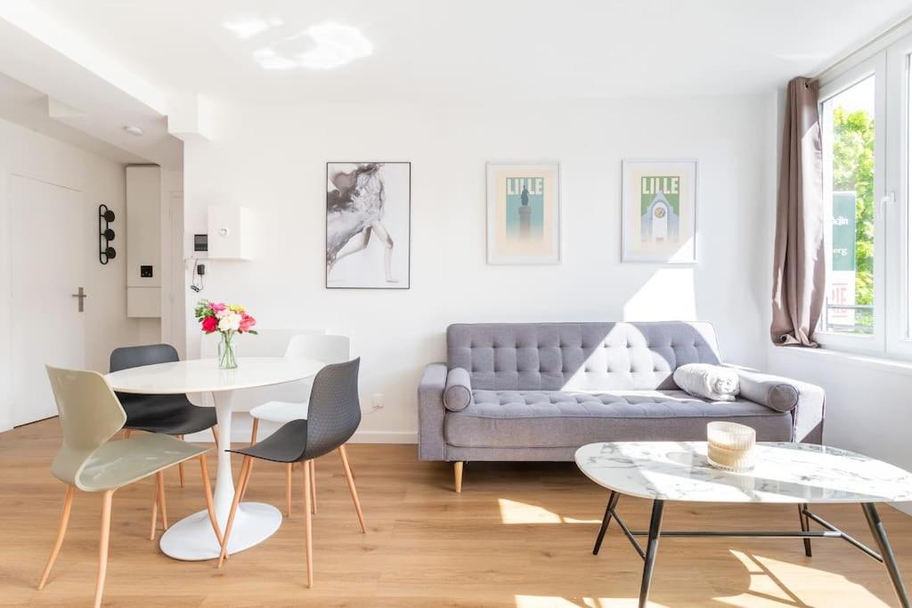 un salon avec un canapé, une table et des chaises dans l'établissement Bel Appartement Cosy proche du métro - Lille, à Lille