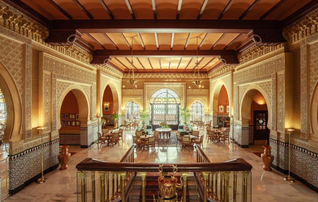 una habitación ornamentada con mesas y sillas en un edificio en Alhambra Palace Hotel, en Granada