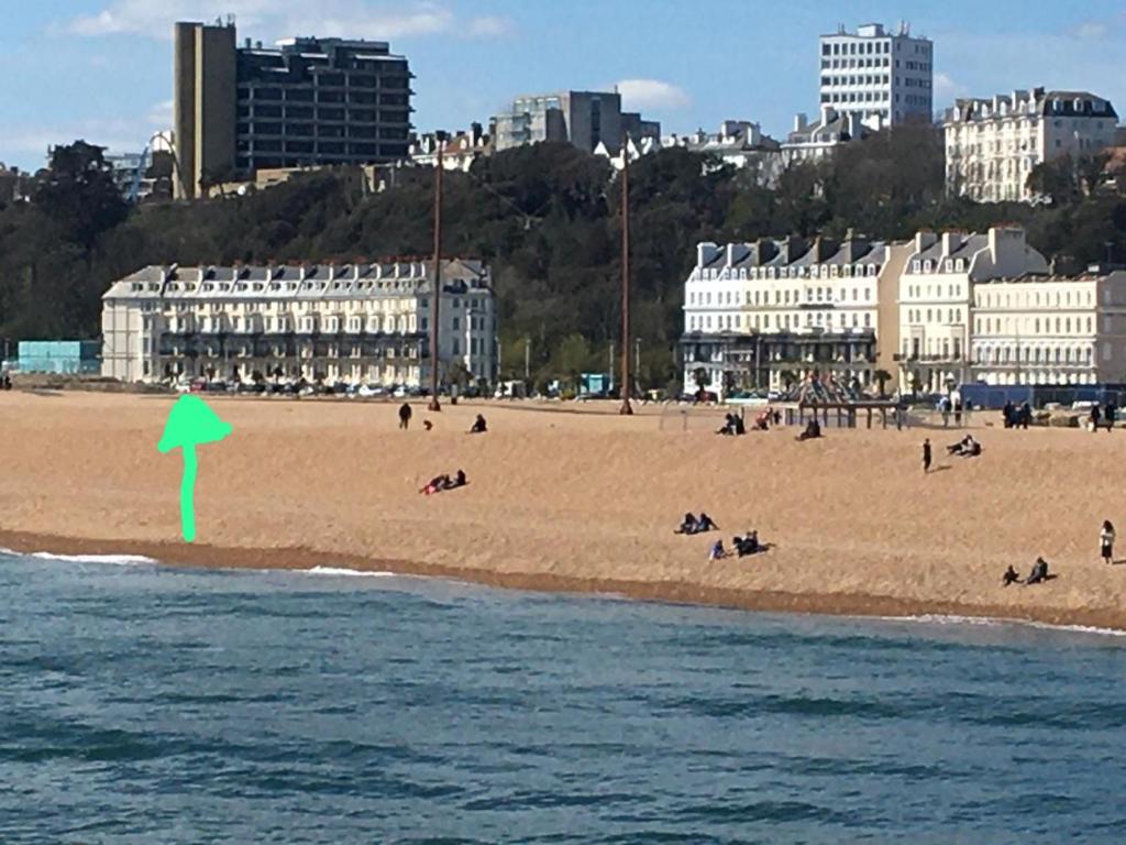 a beach with people on it with a green arrow at Unique seafront 2 bedroom apartment in Folkestone