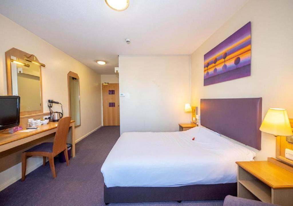 Pokój hotelowy z łóżkiem i biurkiem w obiekcie V Lodge Manchester w Manchesterze
