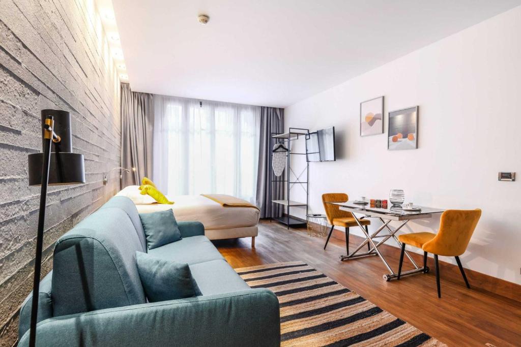 un salon avec un canapé bleu et une table dans l'établissement Residence Fremiet Tour Eiffel, à Paris