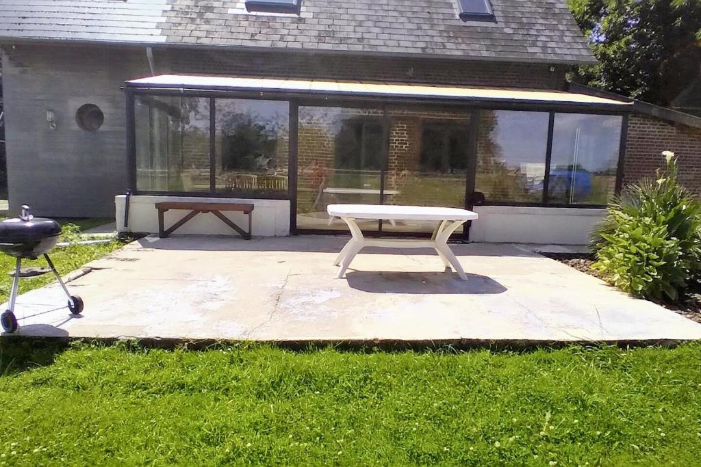 eine weiße Bank, die auf einer Terrasse im Hof sitzt in der Unterkunft Maison de 3 chambres avec jardin clos et wifi a Ecrainville in Écrainville