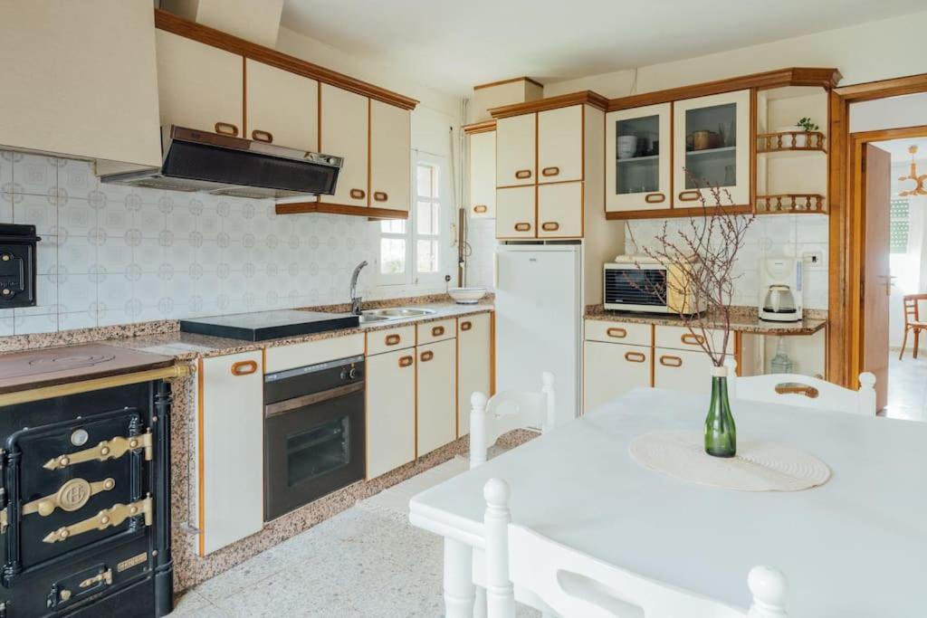 eine Küche mit weißen Geräten und einem weißen Tisch in der Unterkunft Casa Cuco in Corejido