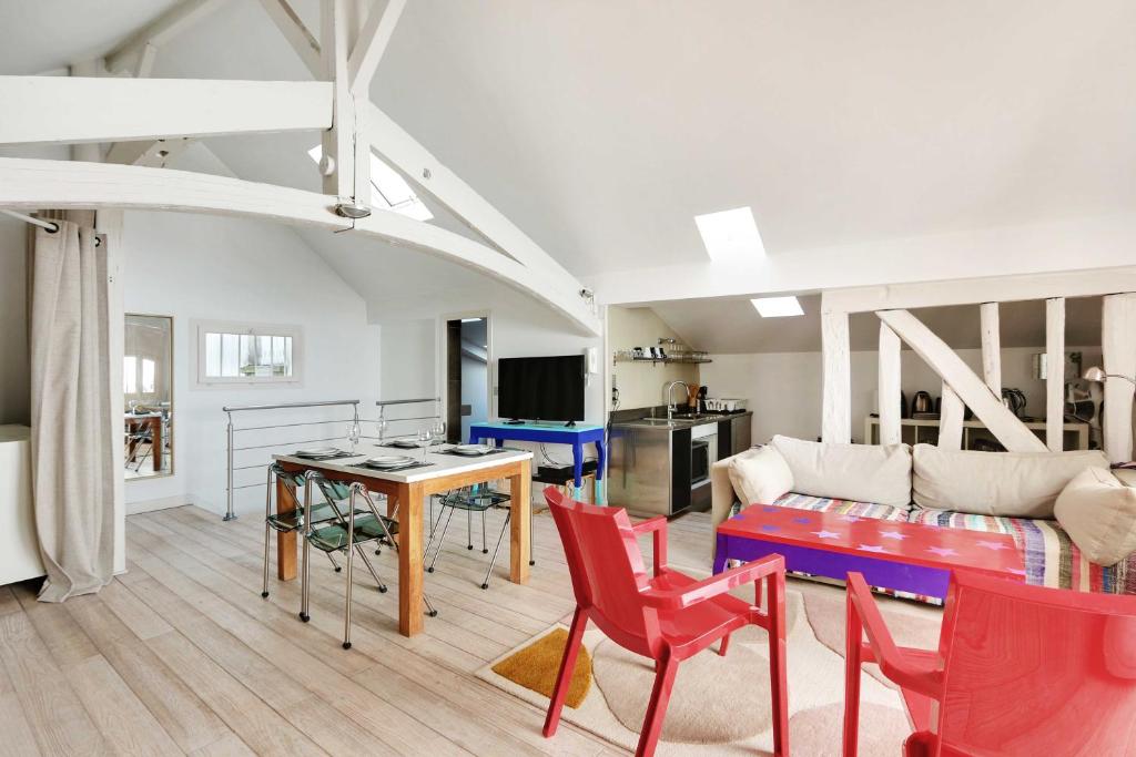 un salon avec une table et des chaises rouges dans l'établissement Cozy appartment avec Terrace - 2BR-4P - Centre de Paris, à Paris
