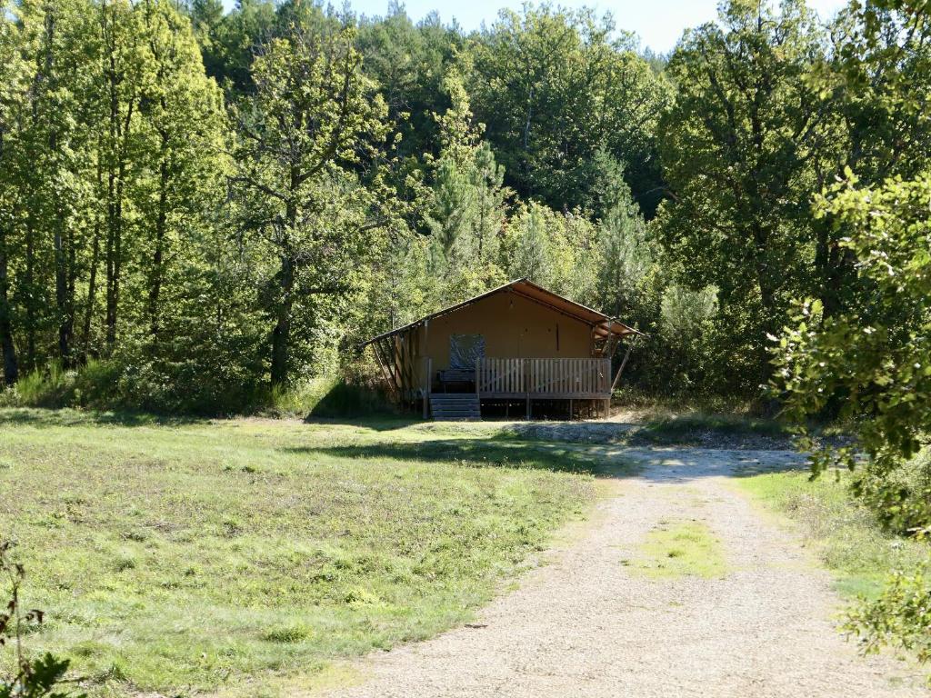 uma cabana no meio de um campo com uma estrada de terra em La Grisonne Chalet 2 em Revest-du-Bion