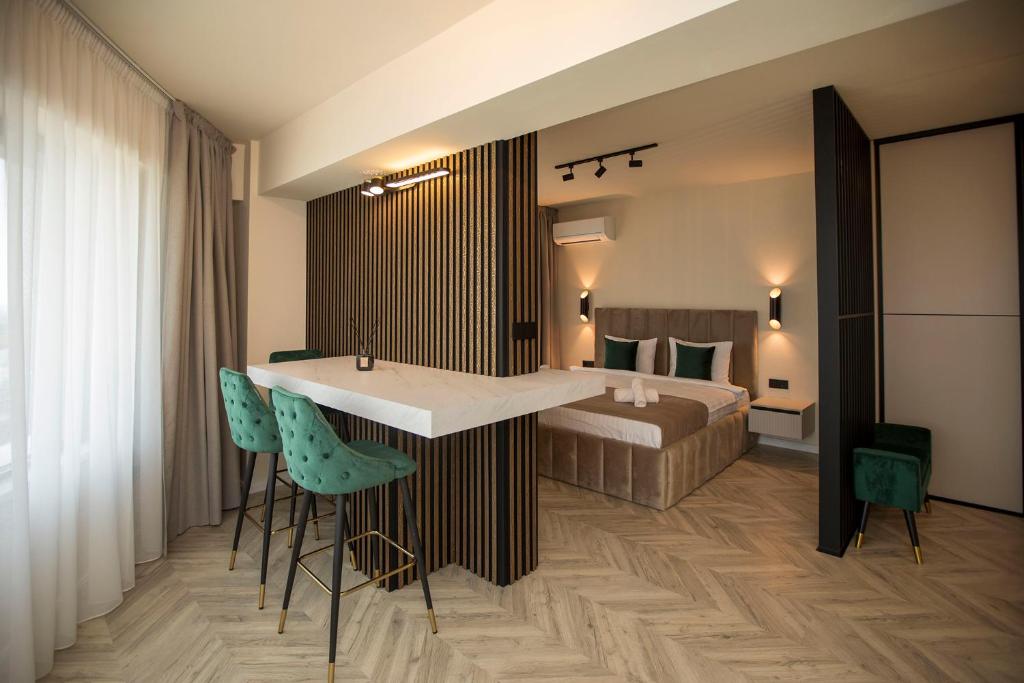 a hotel room with a bed and a table and chairs at Sunset Studio - 12th Floor in Cluj-Napoca