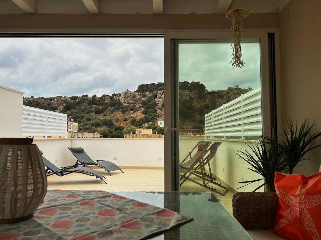 a room with a glass table and a view of a balcony at Memo - Mediterranean Emotions in San Vito lo Capo