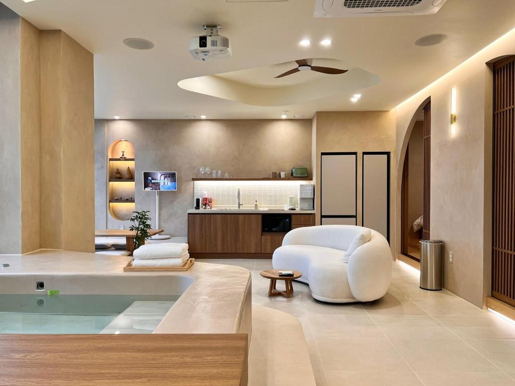 ein Wohnzimmer mit einem weißen Stuhl und einem Tisch in der Unterkunft Gwangan Awesome in Busan