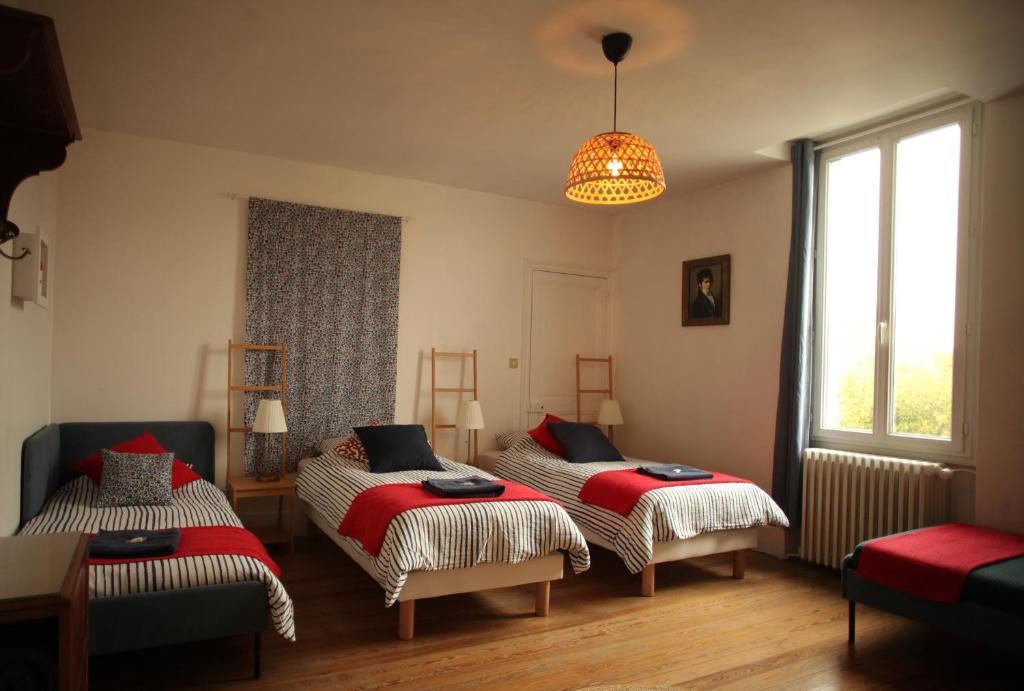 een slaapkamer met 2 bedden en een kroonluchter bij Maison Saint James in Montélimar