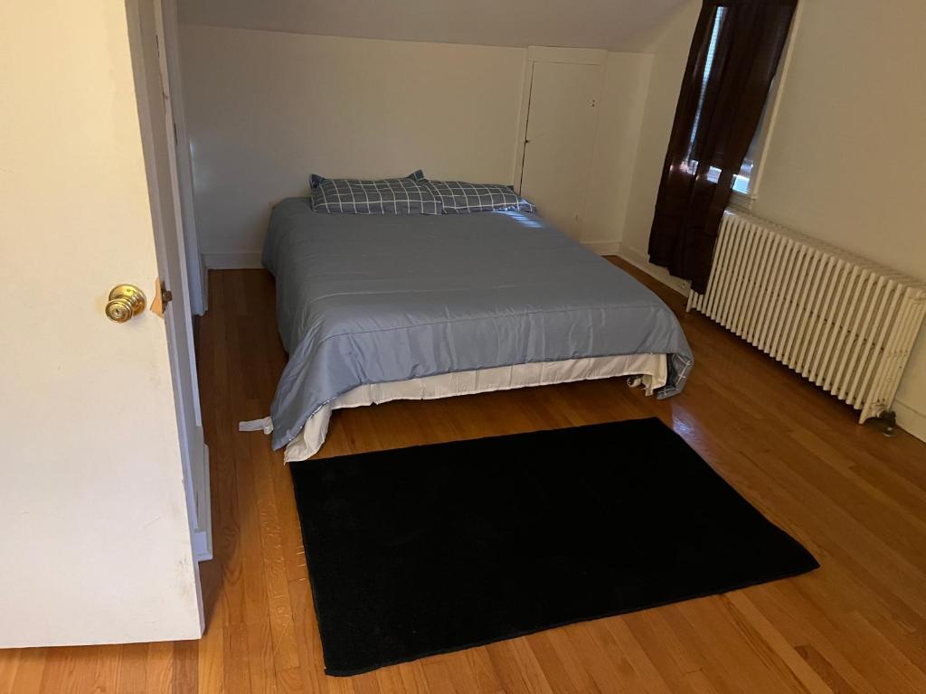 ein kleines Schlafzimmer mit einem Bett und einem schwarzen Teppich in der Unterkunft A beautiful house in Delmar 