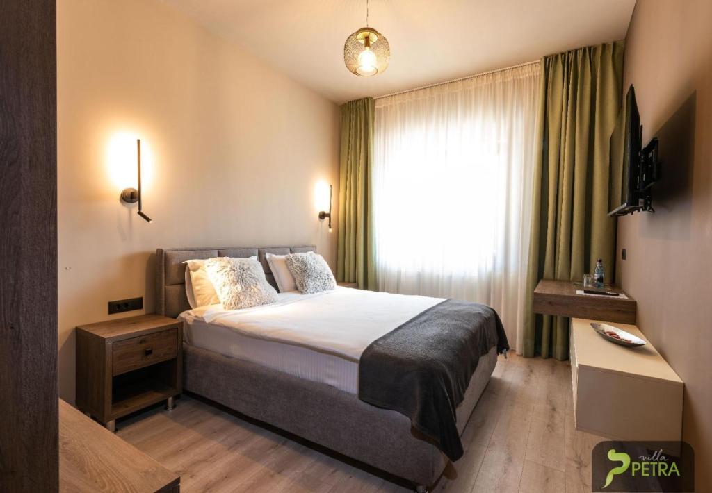 a hotel room with a bed and a window at Villa Petra Residence - Private Parking & Village Life in Cristian