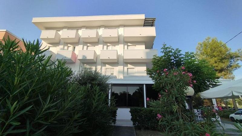a large white building with plants in front of it at Hotel Pigalle in Riccione