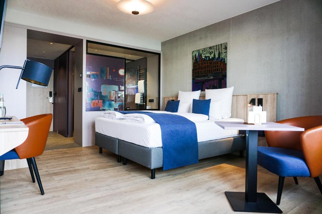 ハンブルクにあるアパートメント - ホテル ハンブルク ミッテのベッド、テーブル、椅子が備わるホテルルームです。