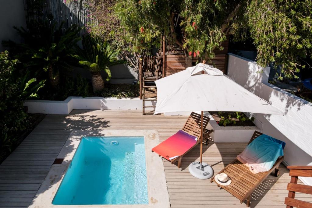 an umbrella and chairs next to a swimming pool at Meliora in Cape Town