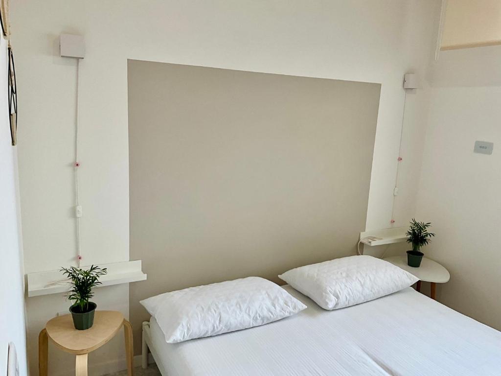 um quarto com duas camas e dois vasos de plantas em SeaSide BnB -Elegante Appartamento- FRONTE MARE em Porto San Giorgio