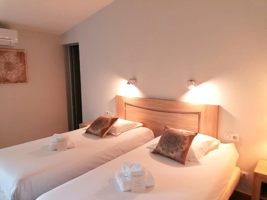 two beds in a hotel room with white sheets at Hôtel Restaurant Platanes - KB HOTEL GROUP in Étauliers