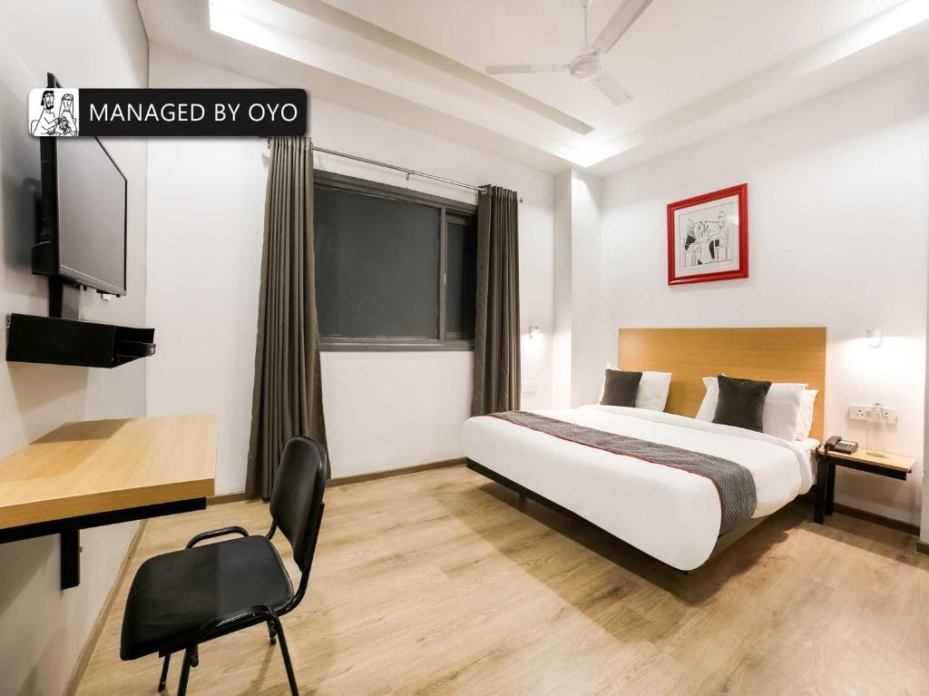 Habitación de hotel con cama y escritorio en Super Townhouse Rohini Sector 23, en Nueva Delhi