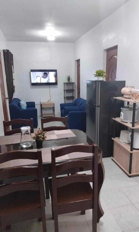 ein Wohnzimmer mit einem Tisch und Stühlen sowie einem Kühlschrank in der Unterkunft DAVAO Transient House 2 in Davao City