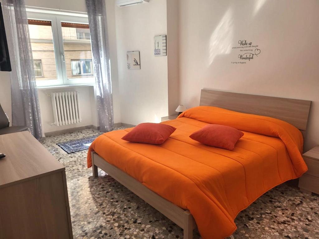 una camera con letto arancione e 2 cuscini di Garibaldi Square Central City a Bari