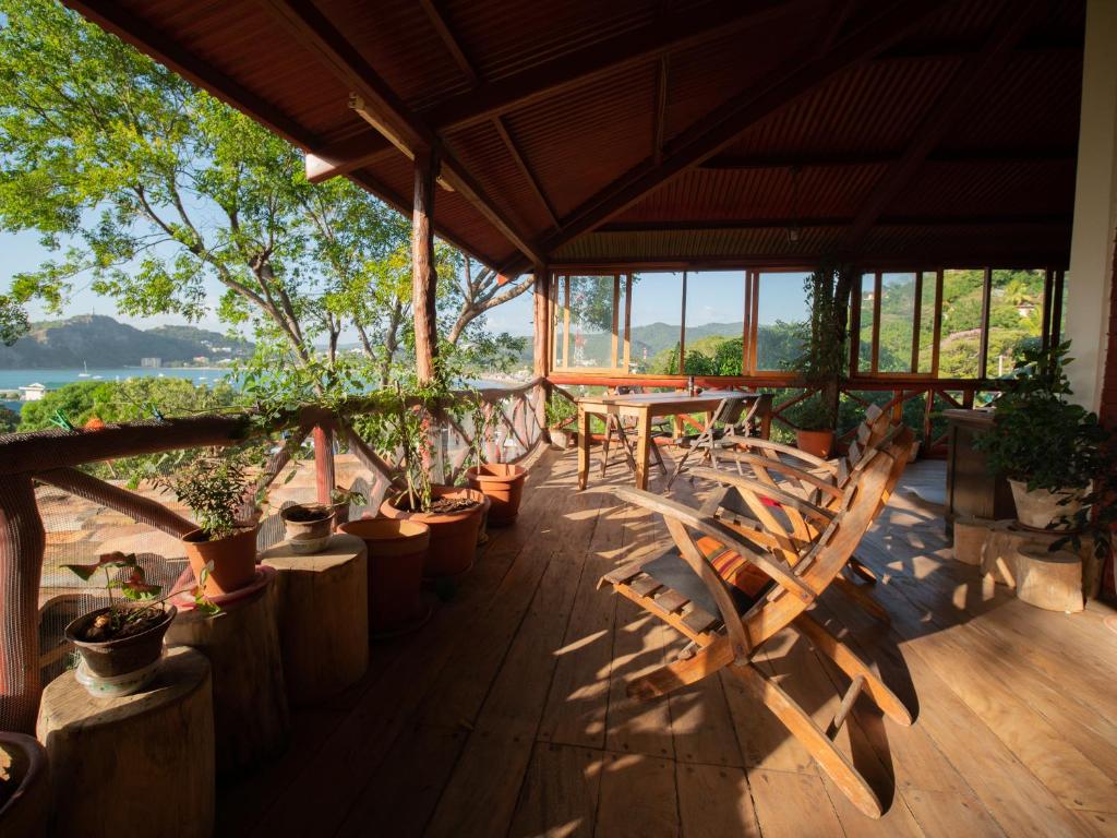 um alpendre com cadeiras, uma mesa e plantas em 300m to beach/center: 2 bedr-2 bath & great views! em San Juan del Sur