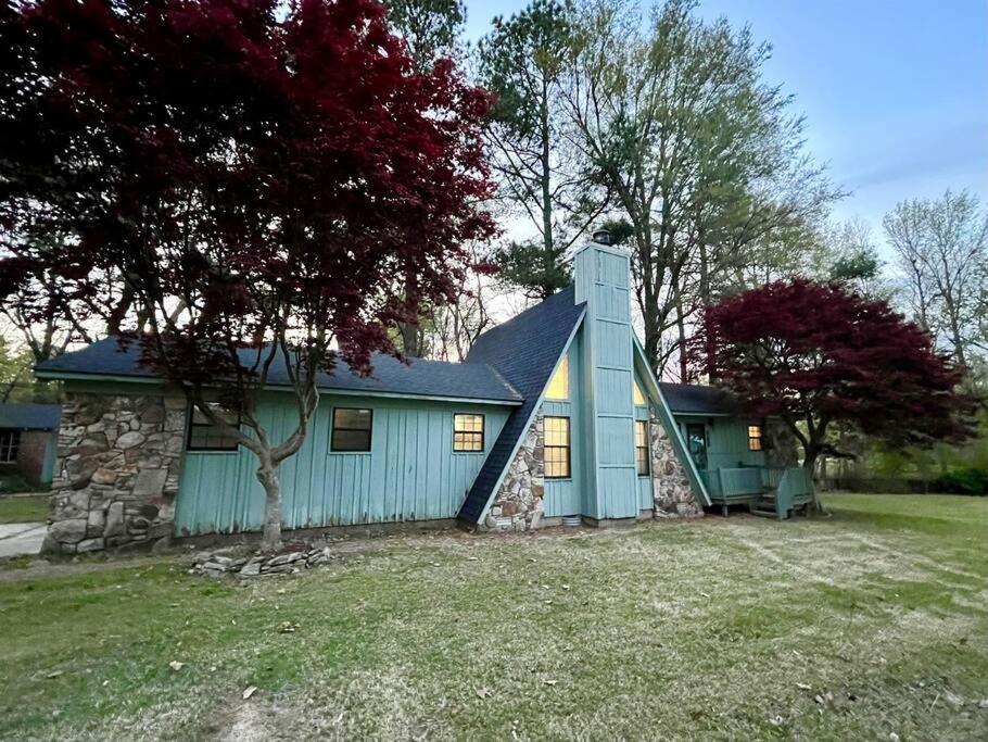 a blue house with a stone wall at Doc's Cottage - A-Frame in Piggott, AR 