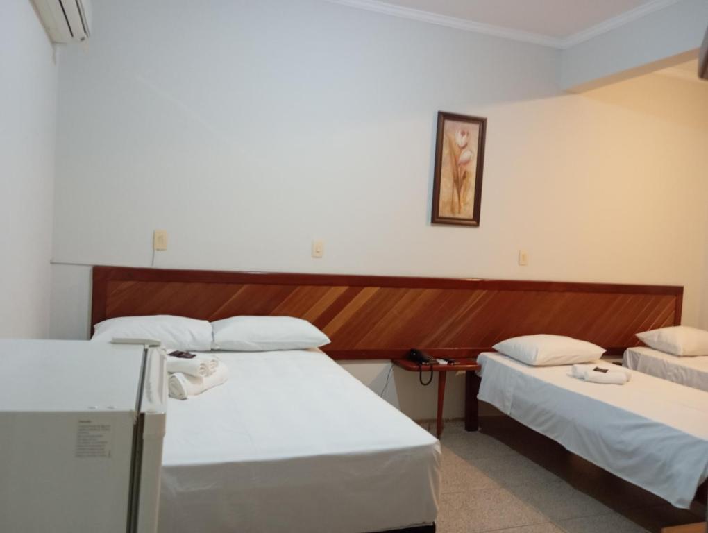 a room with two beds in a room at Mariachis Hotel in Passos