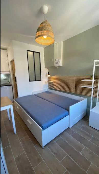 - une chambre avec un lit bleu dans l'établissement La halte, à Villeurbanne