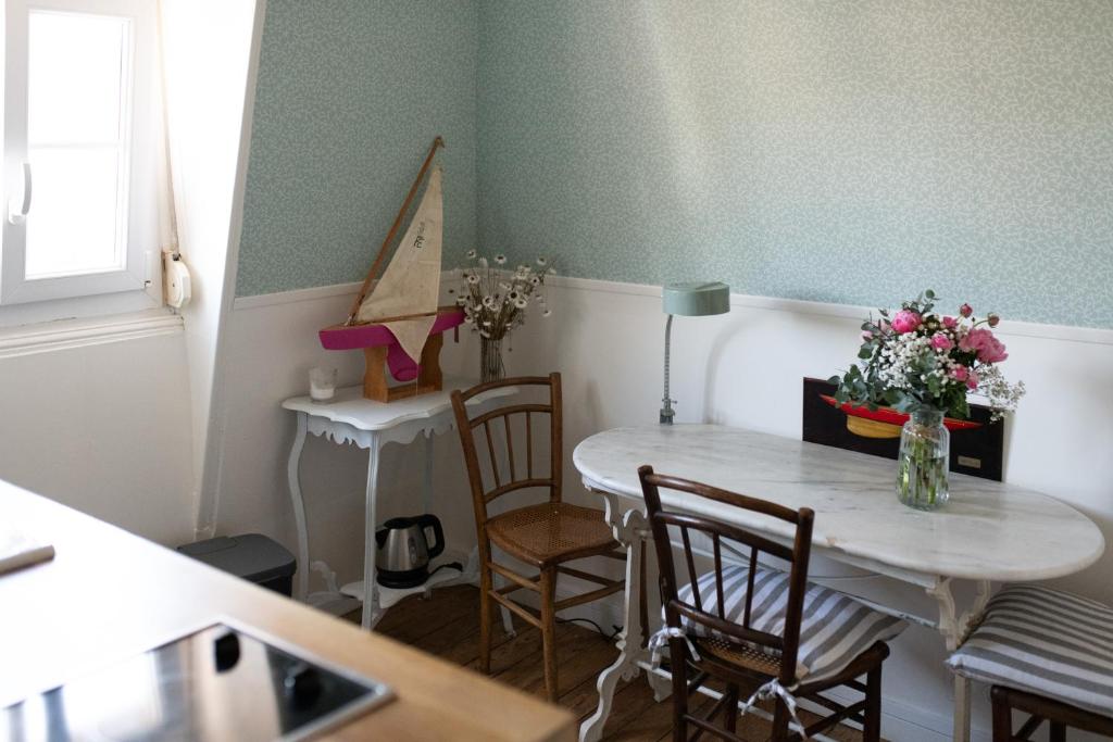 uma cozinha com mesa e cadeiras com flores em La Favorite - app plage à Mers em Mers-les-Bains