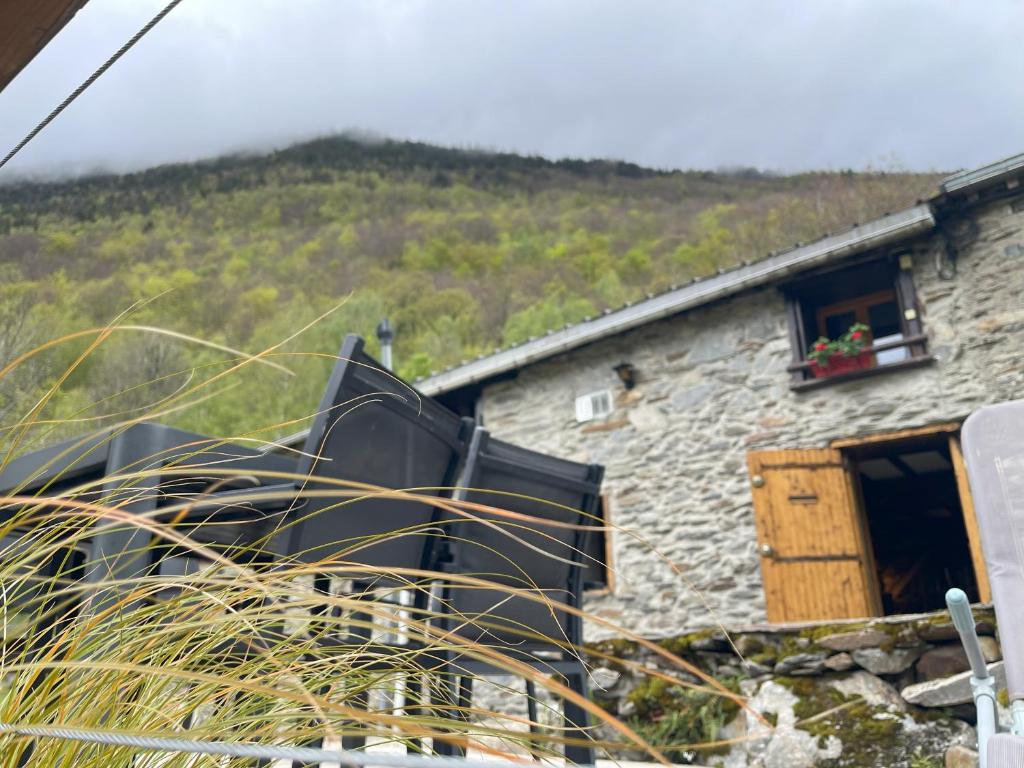 a stone building with a window with a flower box at Grange rénovée, Pyrénées Ariégeoises, Gîte haute Ariège in Auzat