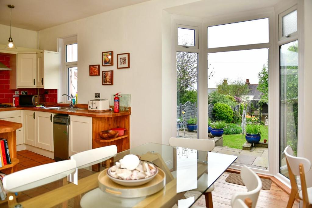 uma cozinha e sala de jantar com uma mesa de vidro em Beautiful family home in Mumbles, with garden em The Mumbles