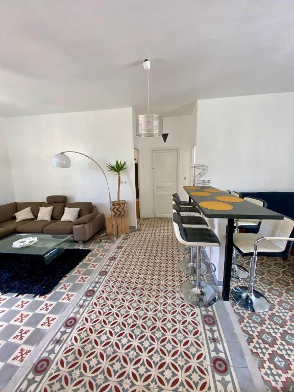 un salon avec un canapé, une table et des chaises dans l'établissement Grand appartement en centre ville avec terrasse, à Perpignan