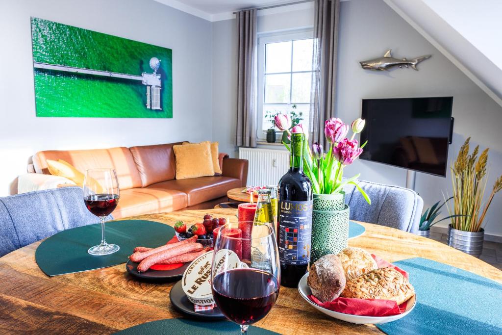 a dining room table with wine glasses and food on it at Birkenstraße 6 Haus II Whg6 in Zingst