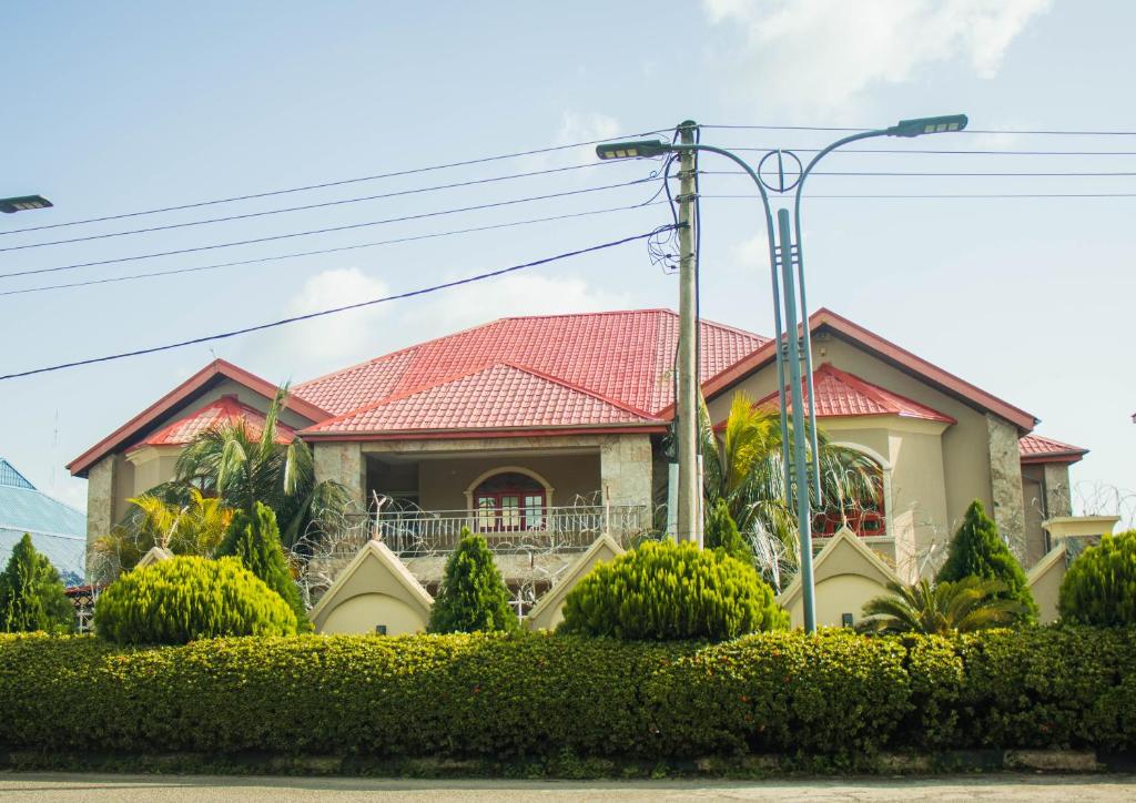 uma casa com um telhado vermelho em J's Place Hotel em Abuja