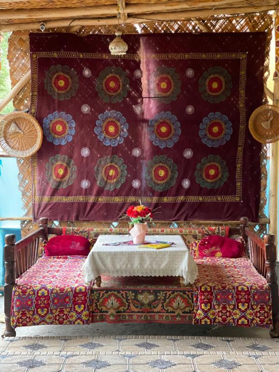 費爾干納的住宿－Sohil boyi，一张带桌子的床,上面有花瓶