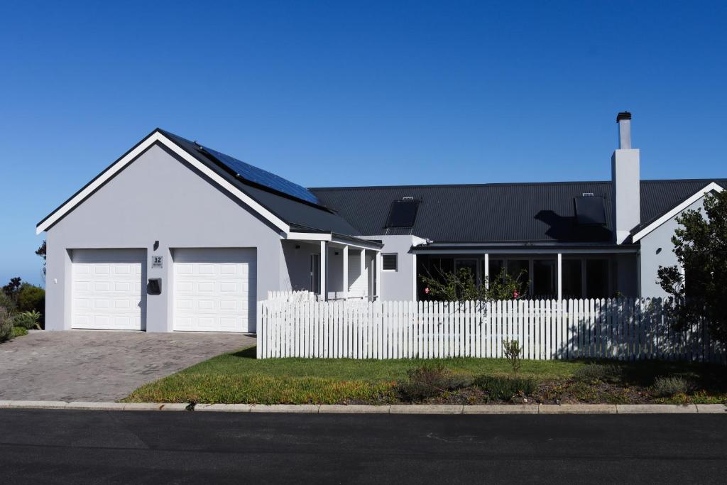 a white house with a fence in front of it at Ocean View - The Unit in Knysna