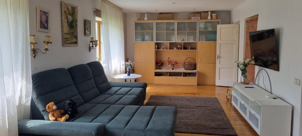 ein Wohnzimmer mit einem blauen Sofa und einem Teddybär in der Unterkunft Sweet Home in Koknese