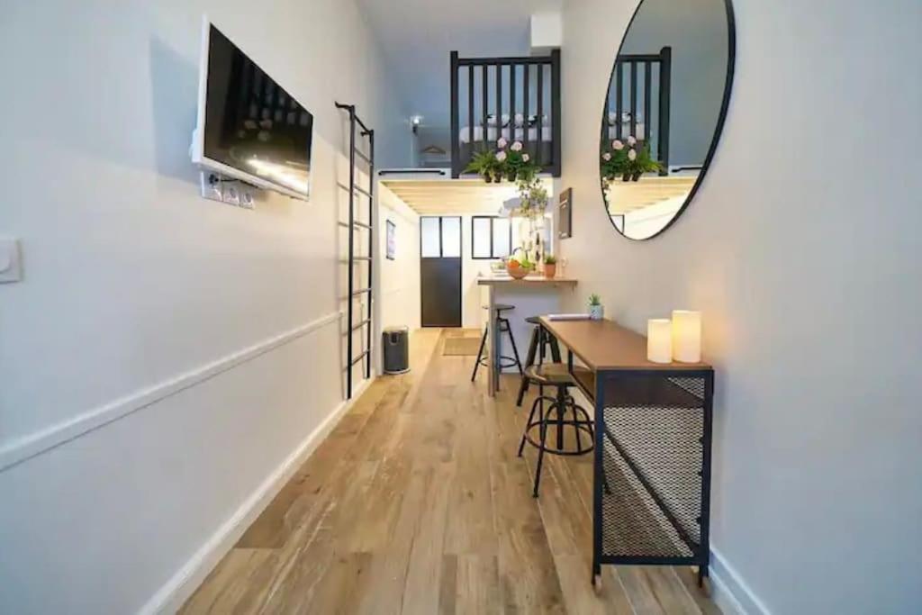 - un salon avec une table et un miroir dans l'établissement Le cozy, à Villeurbanne