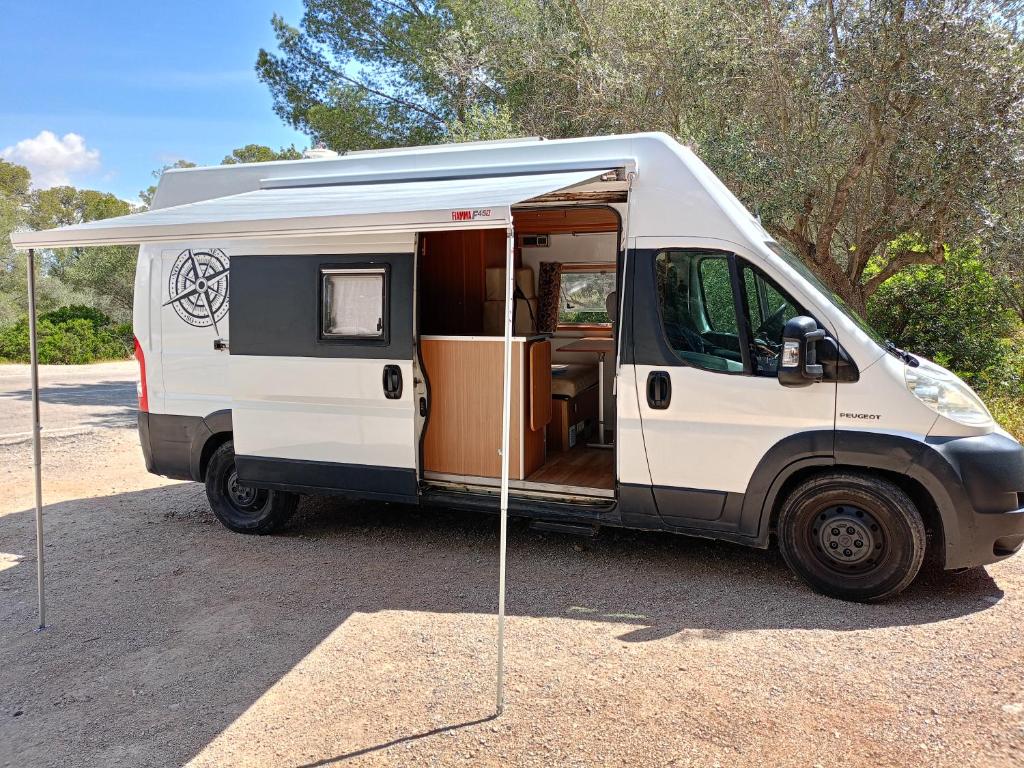 una furgoneta blanca estacionada con la puerta abierta en Furgoneta Camper Gran Volumen, en Palma de Mallorca