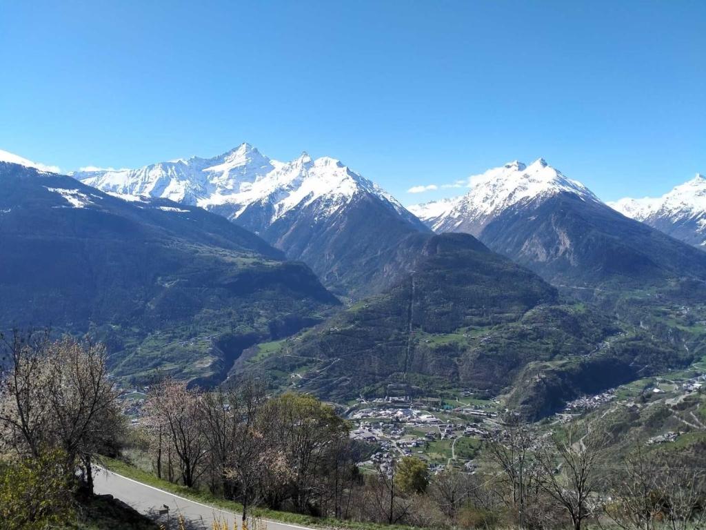 a mountain valley with snow capped mountains in the background at Agriturismo Les Ecureuils in Saint-Pierre