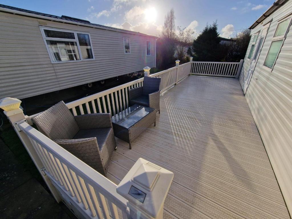 a deck with chairs and a bench on a house at Great Caravan With Spacious Decking Southview Holiday Park, Skegness Ref 33035v in Skegness