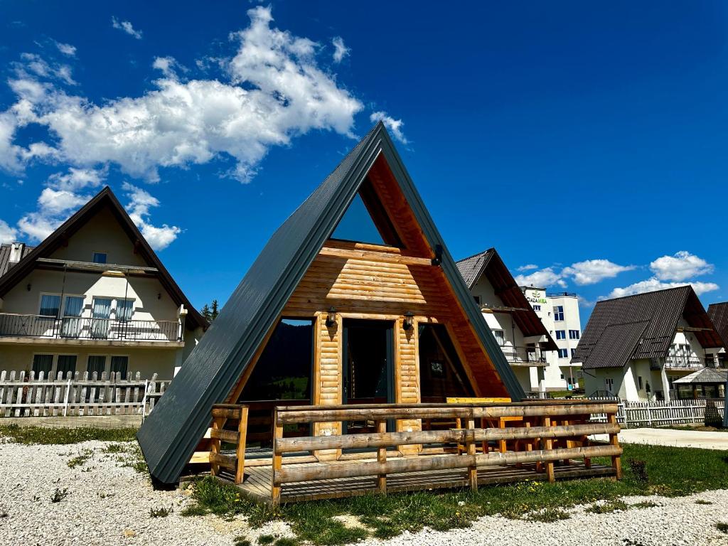 a house with a triangular roof on the beach at Lacky in Vlasic