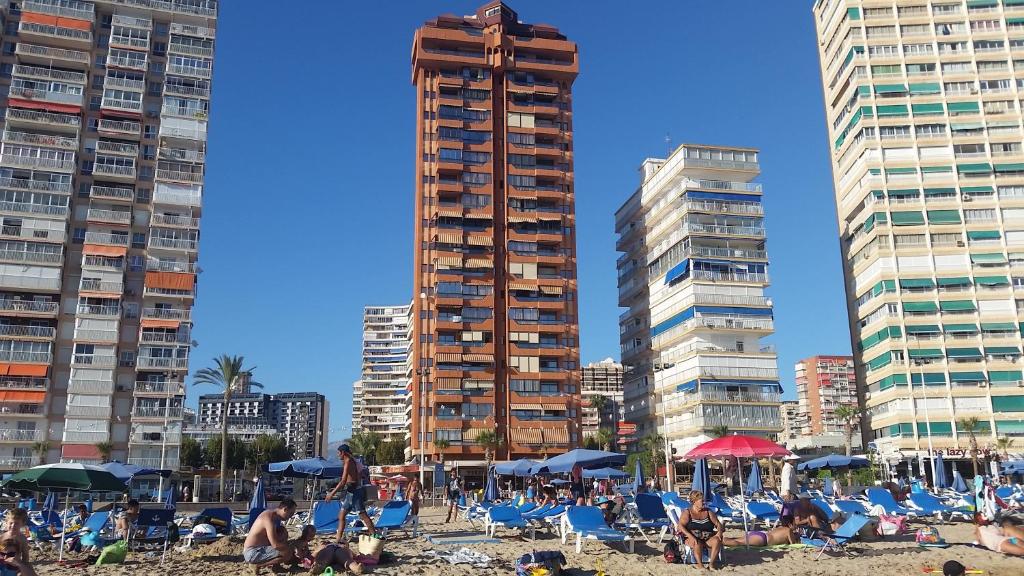 un grupo de personas en una playa con edificios en Apartamentos Don Vicente, en Benidorm
