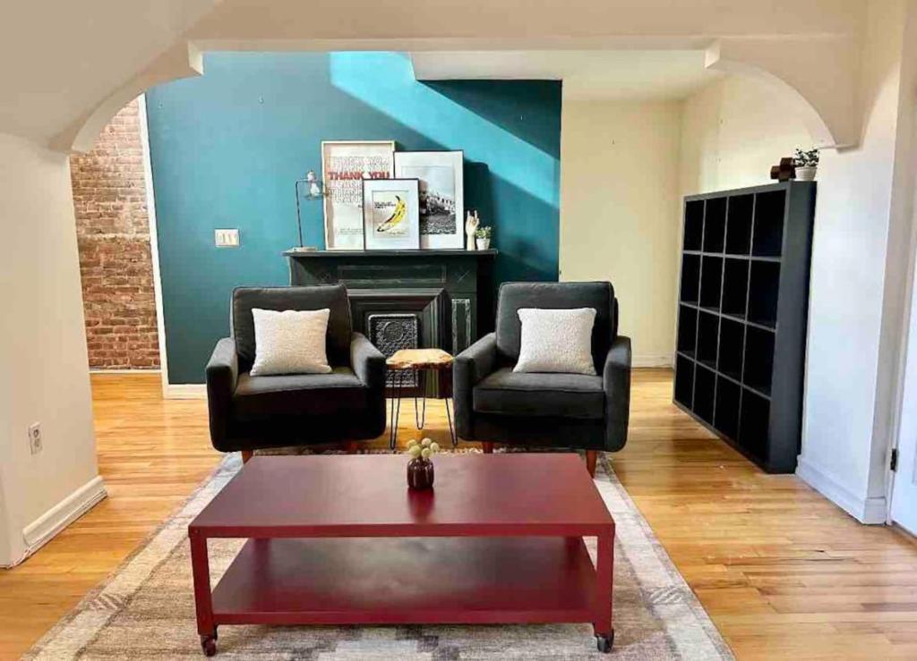 een woonkamer met 2 stoelen en een salontafel bij 330- Unique Uptown W Lofted Bedrooms in Hoboken