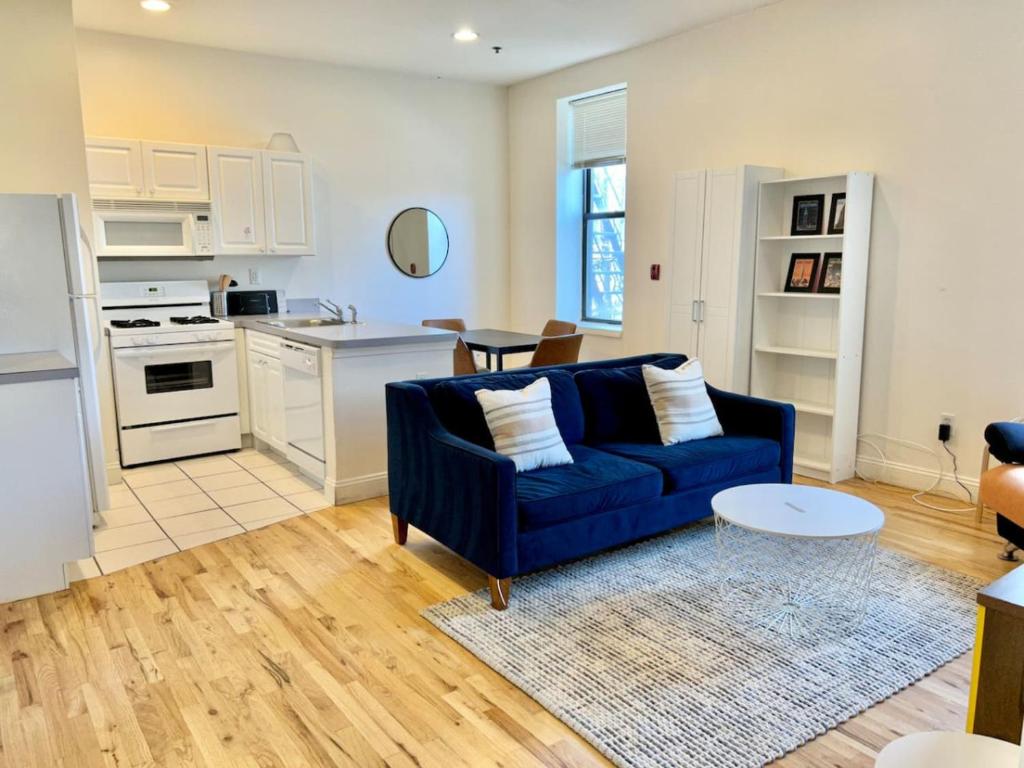 Il comprend un salon avec un canapé bleu et une cuisine. dans l'établissement 222-Cozy Hoboken Apt on Main Street, à Hoboken