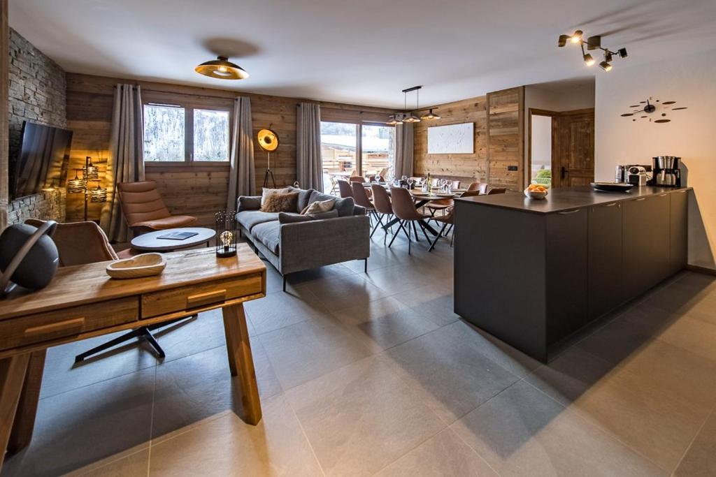 kuchnia i salon z kanapą i stołem w obiekcie Appartement neuf et spacieux au cœur du village avec sauna w mieście Saint-Sorlin-dʼArves