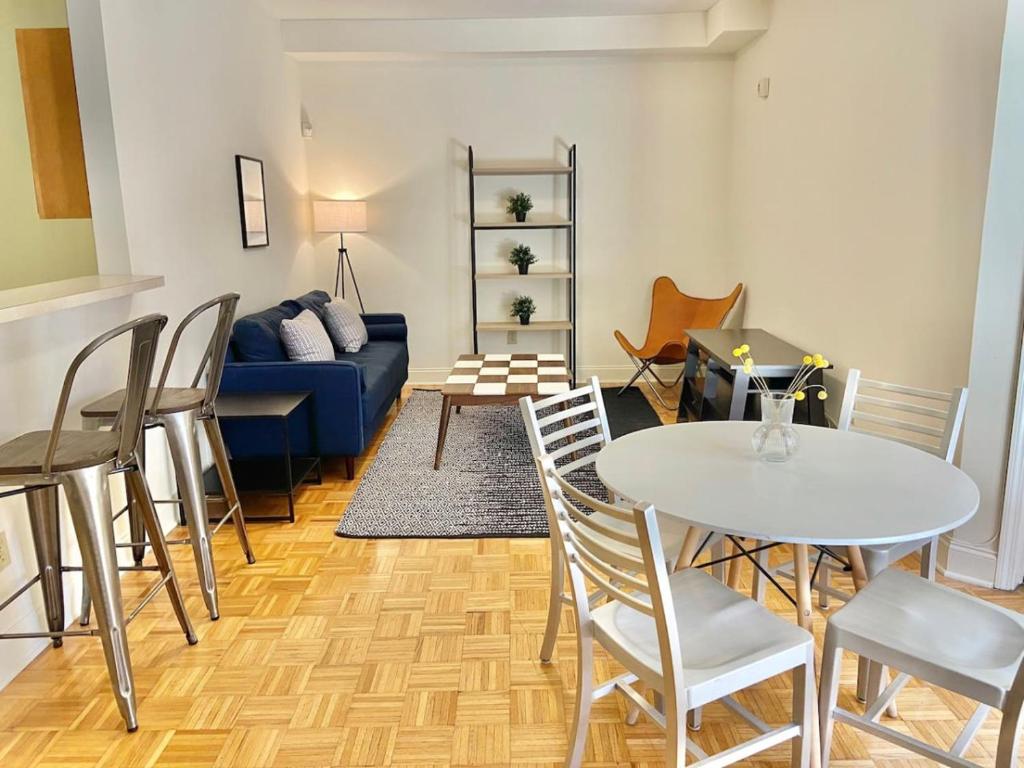 uma sala de estar com um sofá azul e uma mesa e cadeiras em 103-2 Bed Modern Apt in the Heart of Hoboken em Hoboken