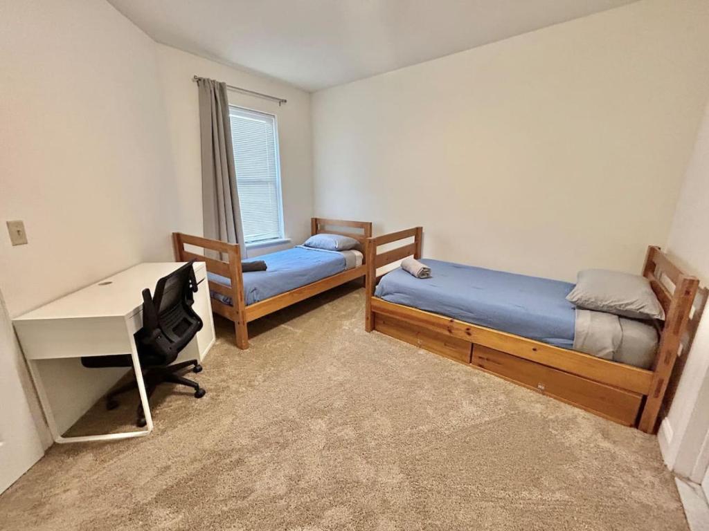 1 Schlafzimmer mit 2 Betten, einem Schreibtisch und einem Schreibtisch in der Unterkunft 0123-Spacious Apartment in the Heart of Hoboken in Hoboken
