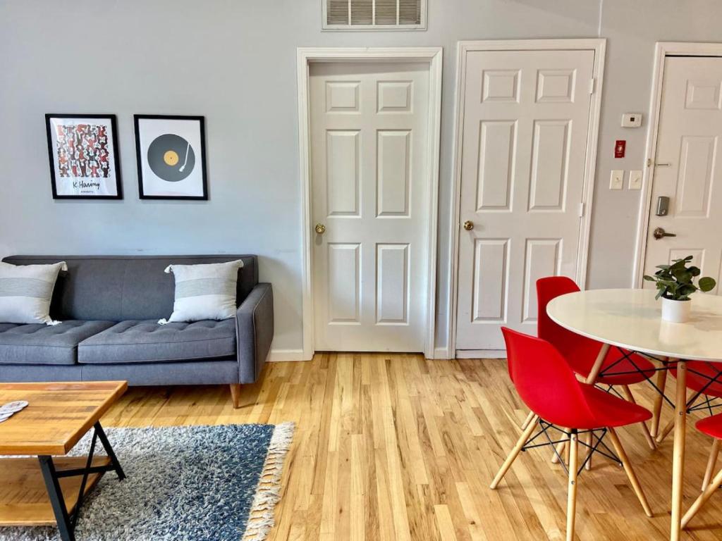 uma sala de estar com um sofá, uma mesa e cadeiras em 212-Two Bedroom Apt.with Patio and Free Laundry em Hoboken